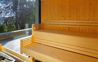 Sauna em madeira com janela panorâmica para a paisagem verde no Cerrado das Fontainhas.
